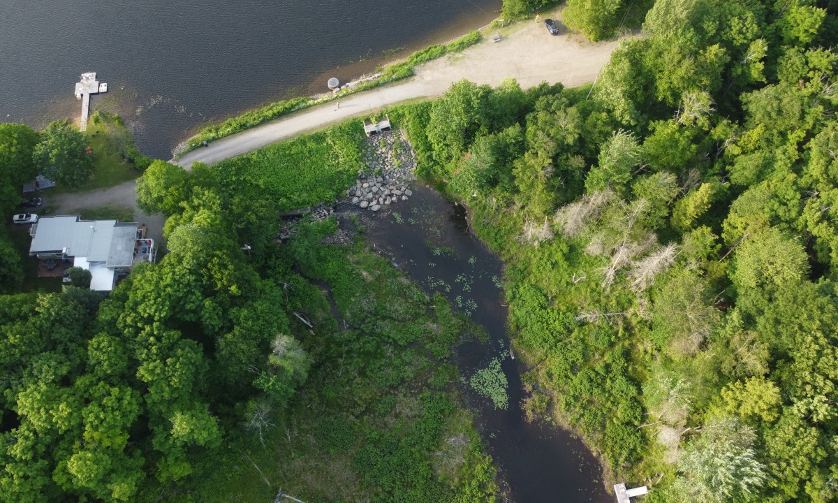 Barrage à faible hauteur avec écoulement visible sur un seuil rocheux dans un environnement naturel  à Roberval