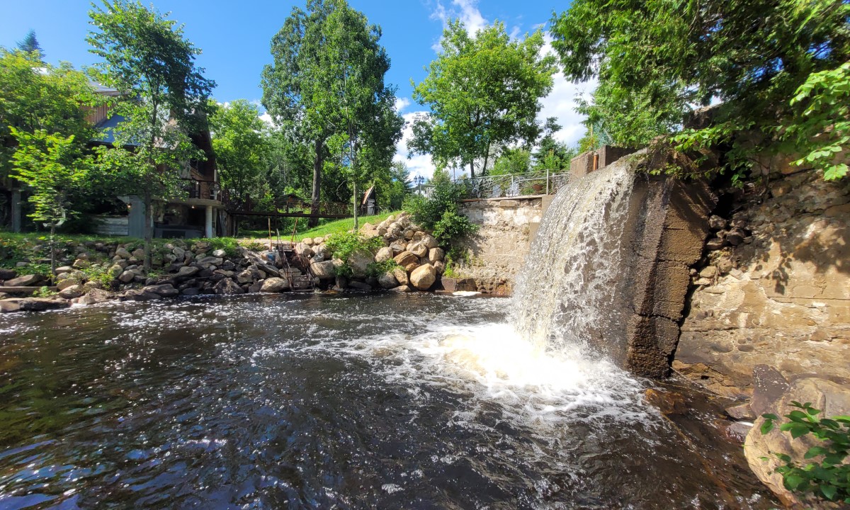 Vue verticale d’un ouvrage de retenue séparant un plan d’eau et un écoulement naturel en milieu boisé  à Saint-Augustin-de-Desmaures