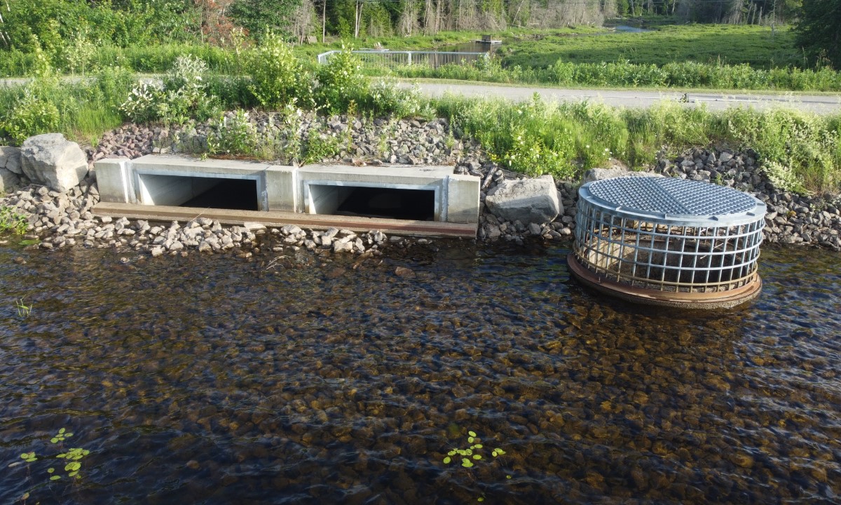 Ouvrage de contrôle de l’eau avec structures en béton et enrochement visible dans un cours d’eau  à Verchères